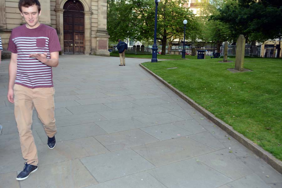 Man looking at his hand, by Birmingham cathedral.