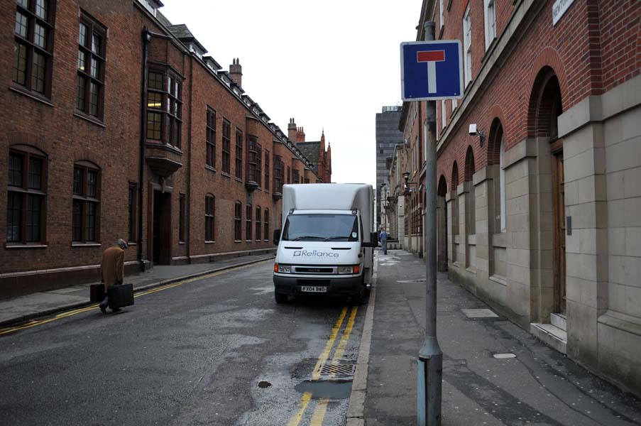 Man with suitcases, back of the magistrates court.