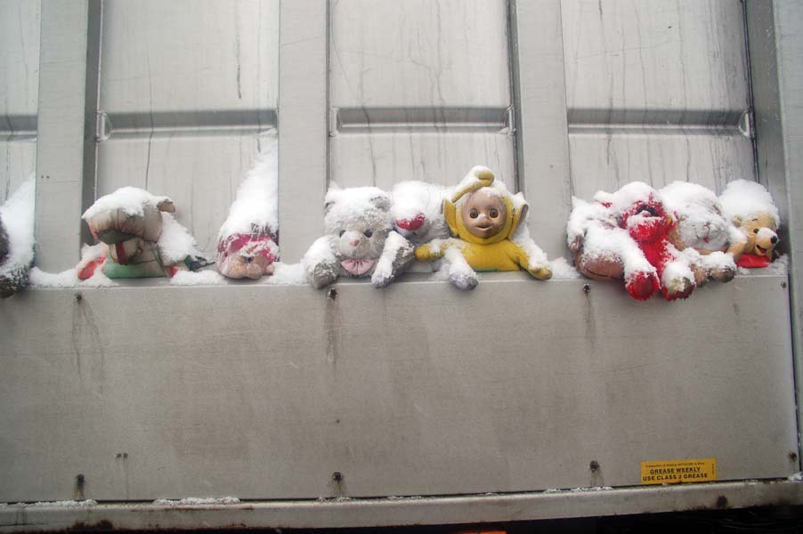 Soft toys on a dust cart.